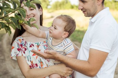 Gün batımında doğada oğluyla oynayıp eğlenen mutlu bir ailenin portresi.