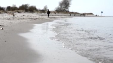 Kuzey Almanya 'da Baltık Denizi' nin sakin havasında kıyı şeridindeki su dalgaları kapanır.