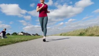 Yavaş çekim 4K video çalıştıran güzel spor kadın bir spor için bir çocuk tarafından geçenleri motive