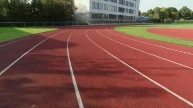 Sporcu formalı genç bir kadın stadyumda hızlı koşuyor. 60fps 4K görüntü