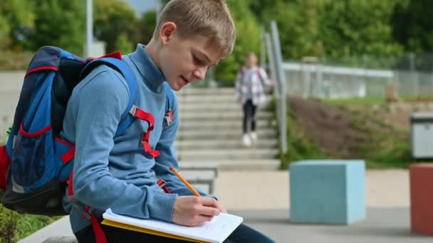 Menino Escola Sentado Escrevendo Livro Excercise Pátio Escola Uma Espera — Vídeo de Stock