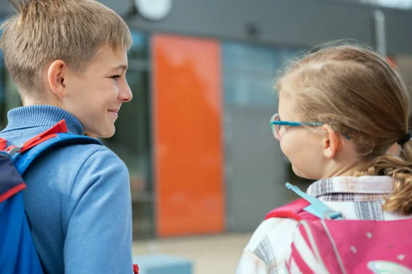 Två Glada Skolbarn Med Ryggsäckar Som Går Och Pratar Campus — Stockfoto