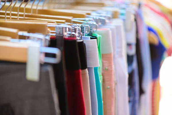Разнообразие одежды висит на стойке в бутике — стоковое фото
