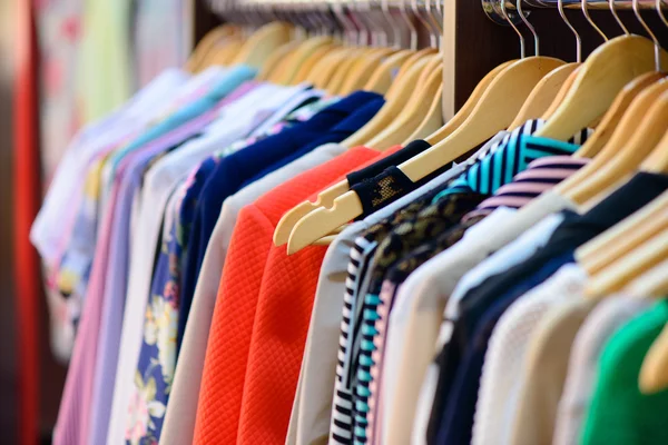 Verscheidenheid van kleren opknoping op rek in boetiek — Stockfoto