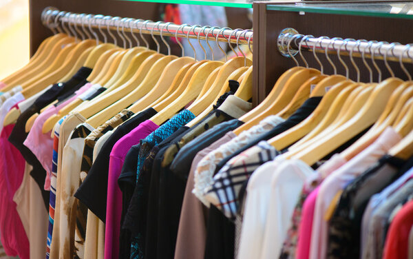 Variety of clothes hanging on rack in boutique