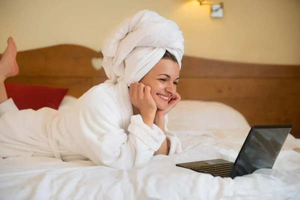 Beautiful woman in bathrobe with laptop — Stock Photo, Image