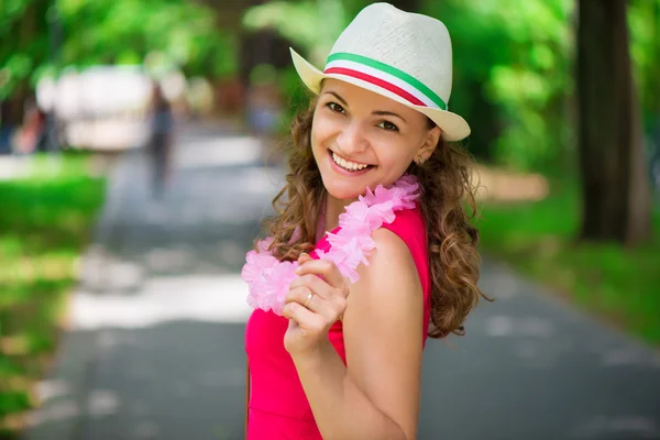 Jonge vrouw in roze jurk in groene zomer park — Stockfoto