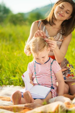 Genç anne kızına saç modeli yaptırıyor