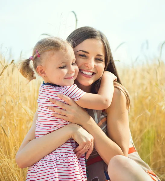 Mooie jonge moeder met dochter zijn gelukkig in zonnige dag — Stockfoto