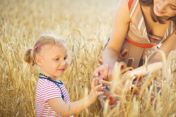 Petite fille avec jeune mère au champ de blé grain — Photo