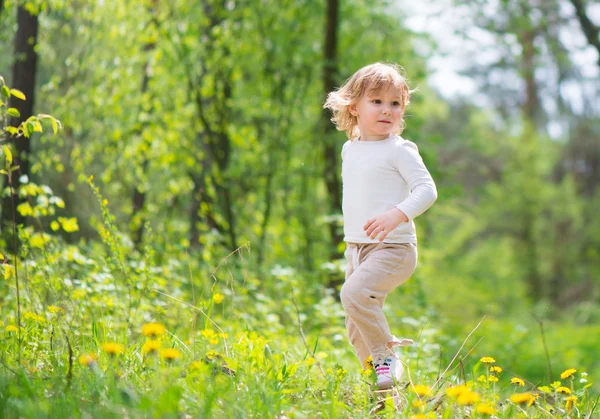 Little blonde girl in green grass — Stock Photo, Image