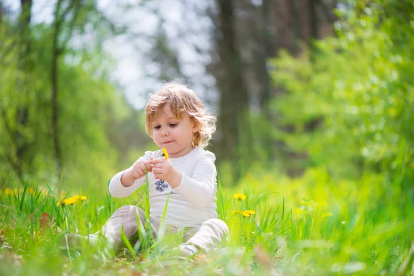 Little blonde girl in green grass — Stock Photo, Image