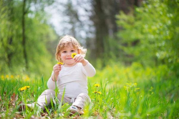 Petite fille blonde dans l'herbe verte — Photo