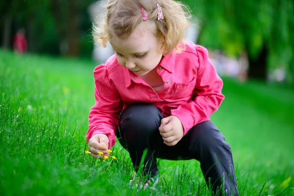 Malá dívka s kudrnatými vlasy v parku — Stock fotografie