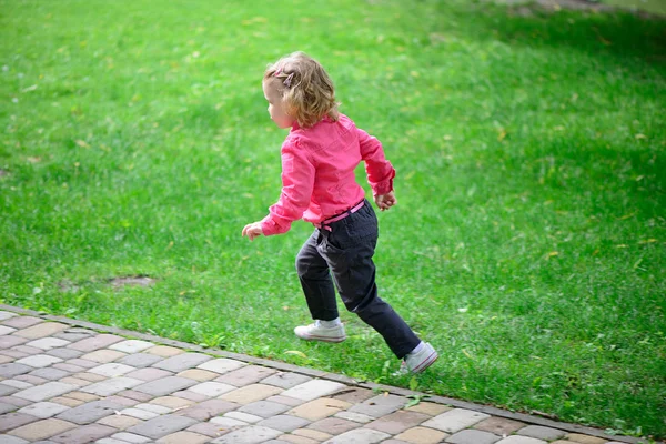 Engraçado menina runing na grama verde — Fotografia de Stock