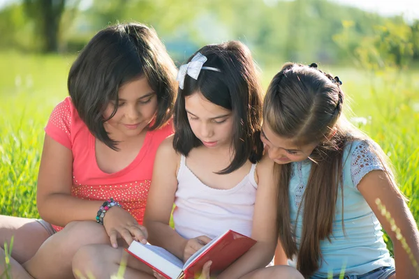 Drie gelukkige tiener meisjes lezen — Stockfoto