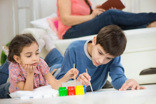 Due bambini che dipingono con vernici colorate a casa — Foto Stock