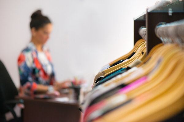 Variety of clothes hanging on rack in boutique