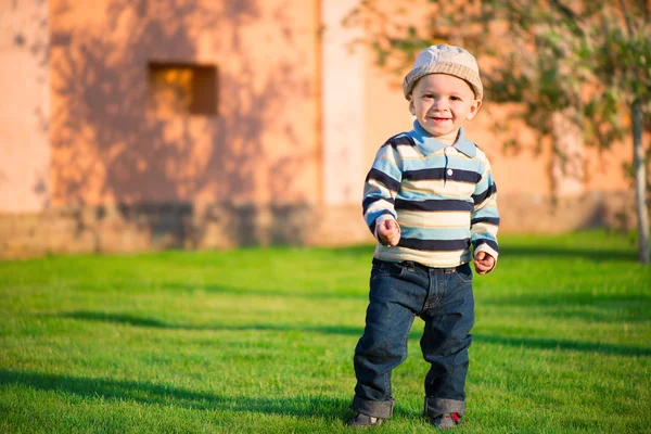 Маленький хлопчик грає на зеленій траві — стокове фото
