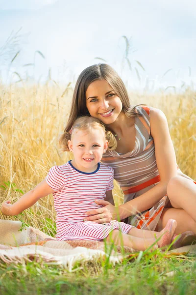 Hübsche junge Mutter mit Tochter sind glücklich bei sonnigem Tag — Stockfoto