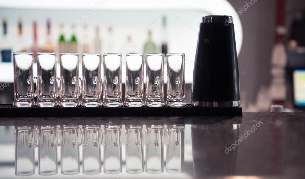 Row of glass shots at bar