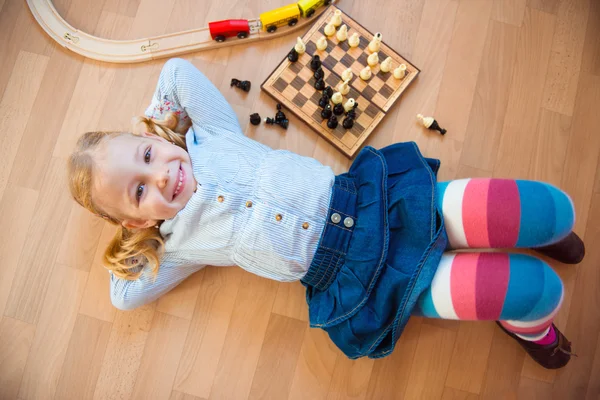 Menina bonito feliz deitado no chão — Fotografia de Stock