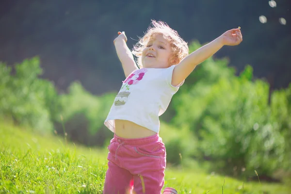 Милая маленькая девочка на солнечном лугу — стоковое фото