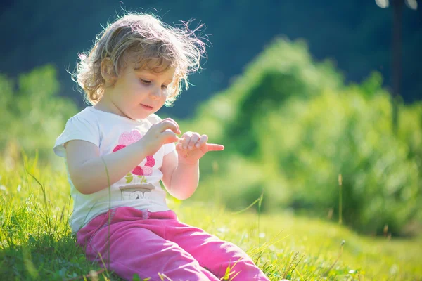 Nettes kleines Mädchen auf der sonnigen Wiese — Stockfoto