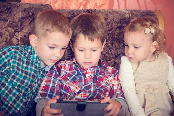 Tres niños pequeños jugando con la tableta PC —  Fotos de Stock