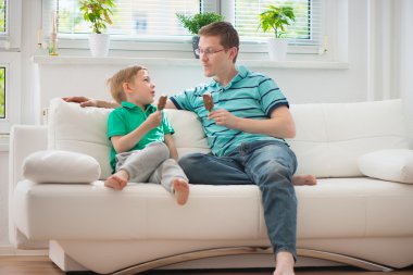 Happy father and little boy eating ice-cream