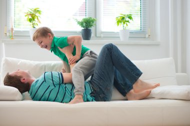 Little boy having fun with father at home