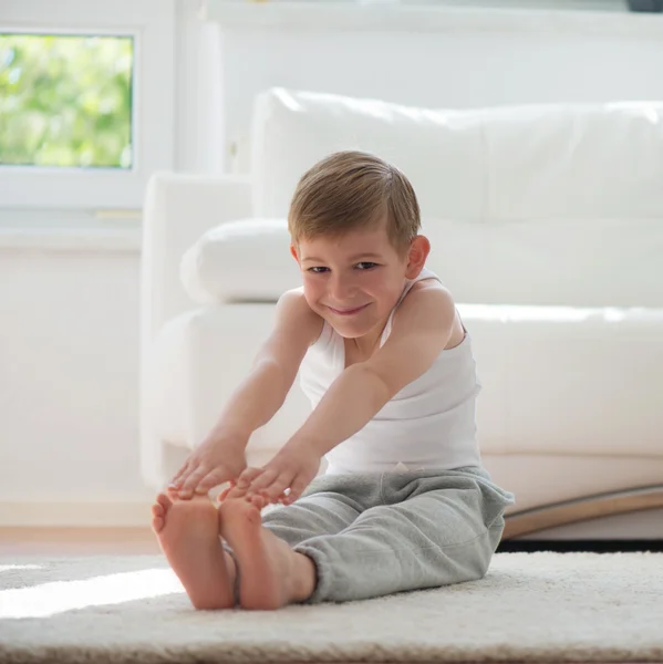 Happy little  boy exercising at home — Stockfoto