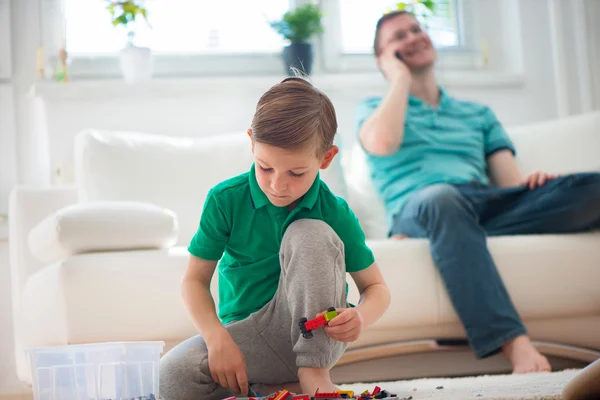 Niño pequeño jugar, padre con telefon —  Fotos de Stock