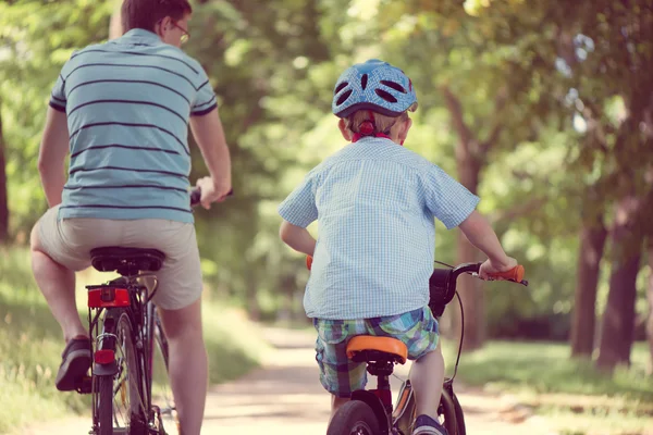 Feliz padre e hijo montan en bicicletas — Foto de Stock