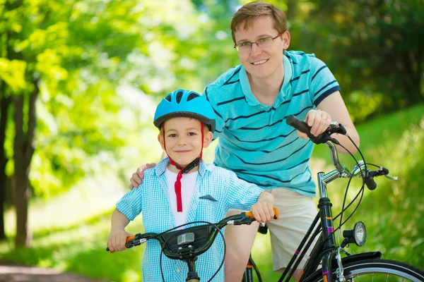 Lycklig far och son rida på cyklar — Stockfoto