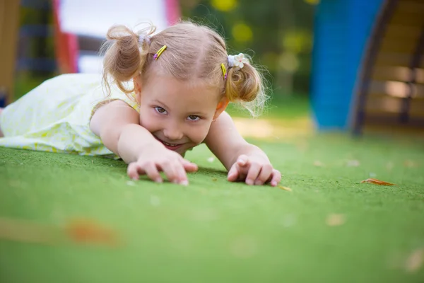 Счастливая девочка играет на детской площадке — стоковое фото