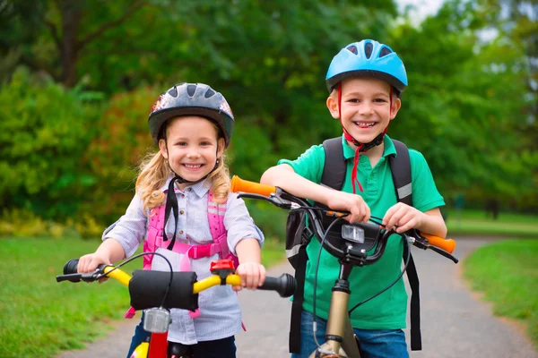 Двое детей на велосипеде в парке — стоковое фото