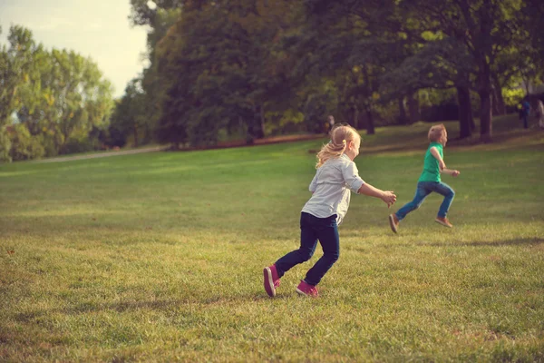 Glückliche Kinder rennen im Park — Stockfoto