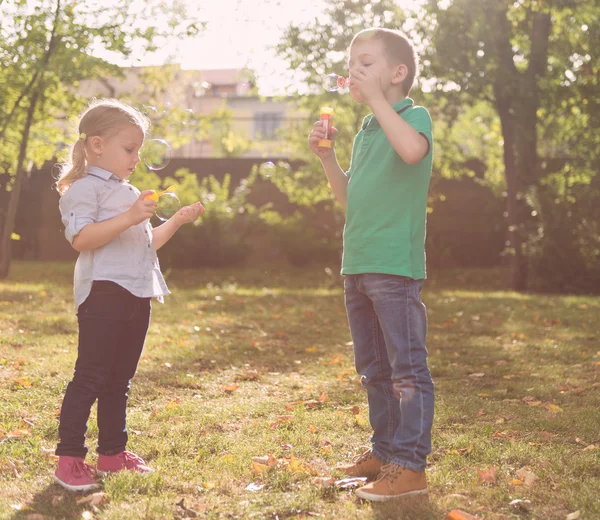 Niños soplando burbujas de jabón al aire libre — Foto de Stock