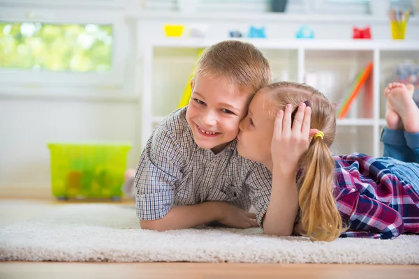 Маленькая девочка целует своего счастливого брата — стоковое фото