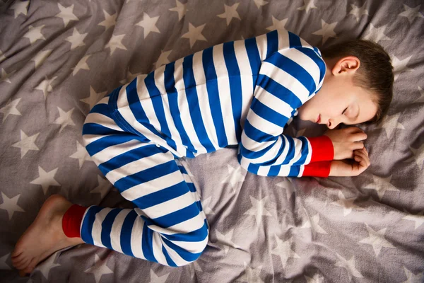 Cute little boy sleeps in pajames on bed. Fokus above — Stock Photo, Image