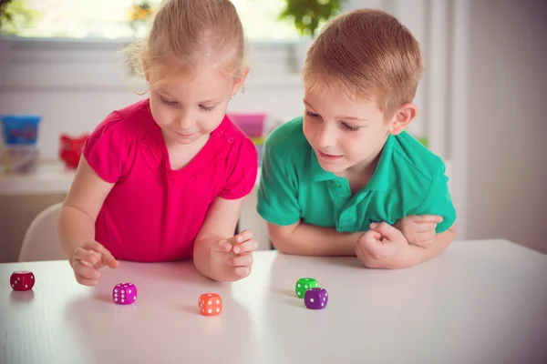 Duas crianças felizes brincando com dados — Fotografia de Stock