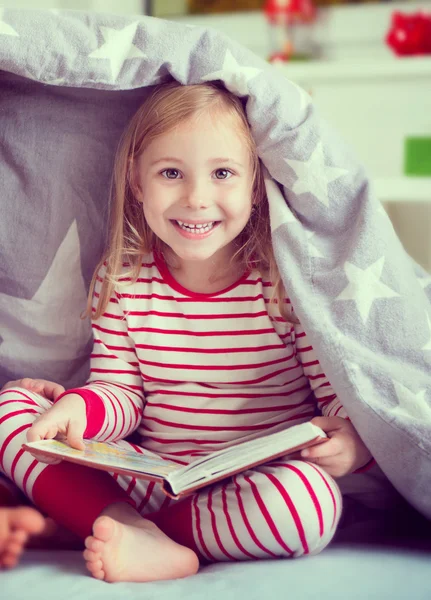 Bella bambina seduta sotto la coperta — Foto Stock