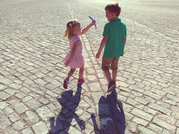 Щасливі діти біжать у сонячному місті — стокове фото
