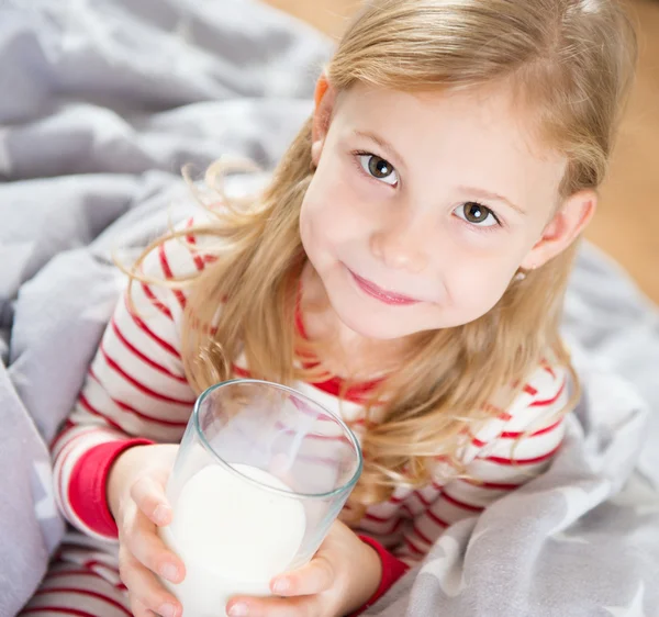 Schattig klein meisje met glas melk — Stockfoto