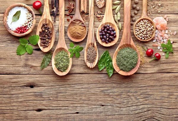 Hierbas y especias en una tabla de madera — Foto de Stock