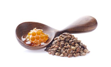 Propolis tanecikleri ve beyaz sırtüstü bal petekli ahşap kaşık.