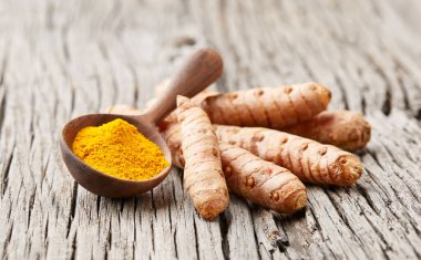 Eski ahşap arka planda köri tozuyla zerdeçal kökleri