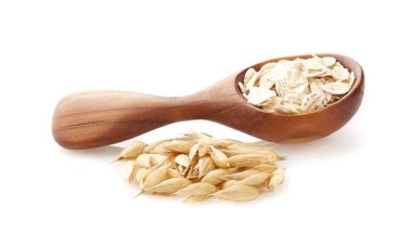 Tahta kaşıkta yulaf ezmesi ve beyaz arka planda yulaf.