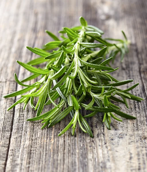 Rosemary em um fundo de madeira — Fotografia de Stock